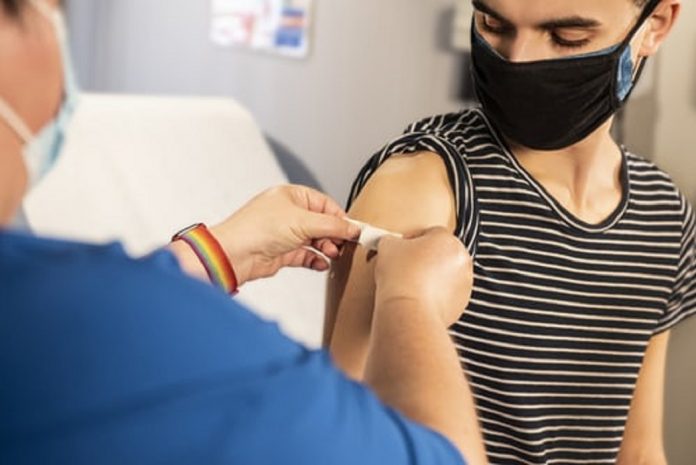 RAGAZZO CHE VIENE VACCINATO Ragazzo che sta venendo vaccinato