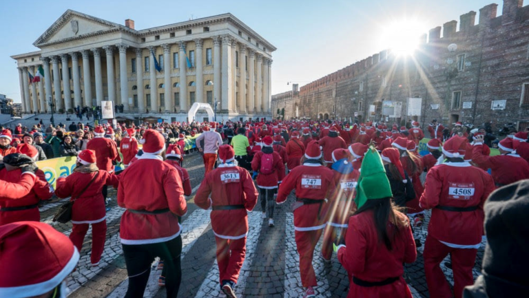 Un'immagine festosa dei partecipanti alla Christmas Run sotto Palazzo Barbieri (Foto Archivio)