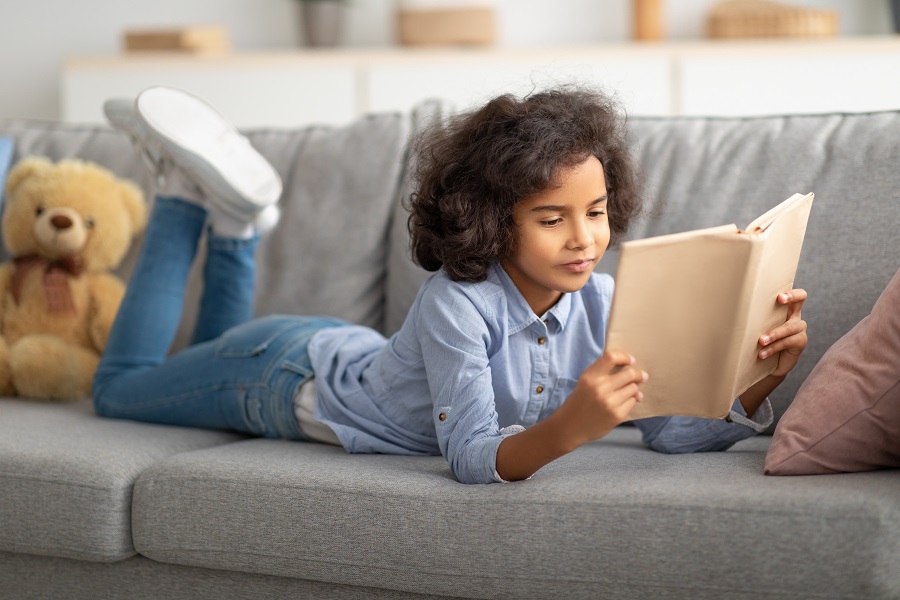 Una ragazzina che legge un libro.