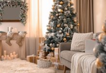 Com’è nata la tradizione dell’albero di Natale? Immagine moderna di un salotto assorto in una calorosa atmosfera natalizia resa speciale da un ben decorato albero di Natale. Da Mondoviro