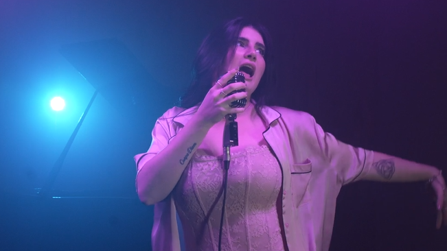 Maria Tomba canta sul palco con un pigiama