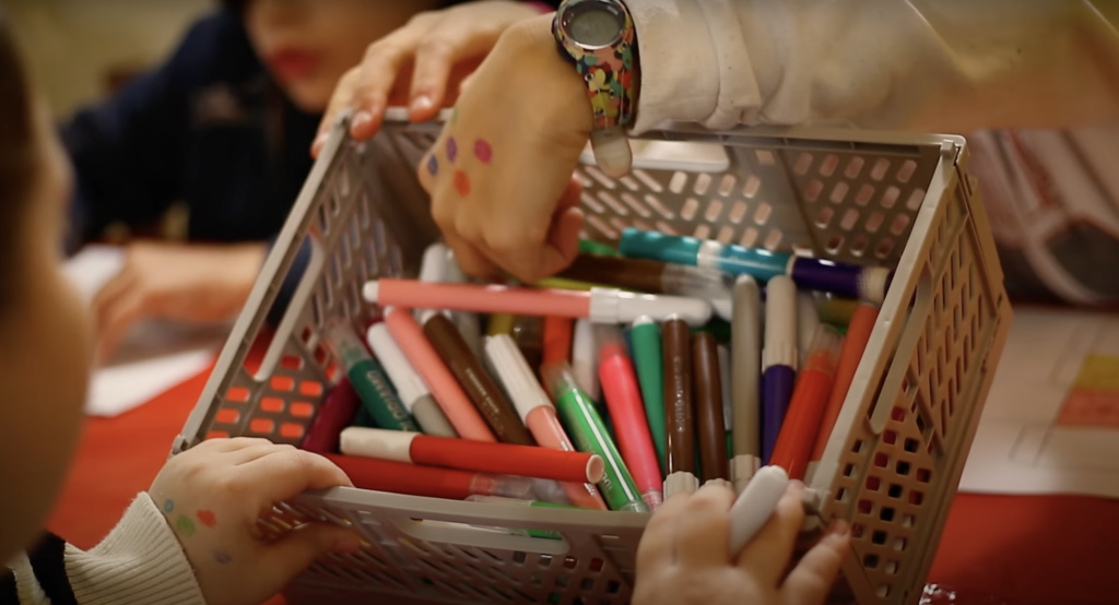 Immagine di due bambini che prendono i pennarelli per colorare