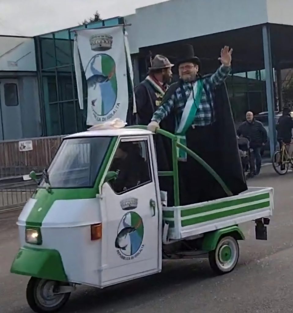 Paolo De Togni, sindaco della Repubblica di Isolalta, a bordo dell'iconica Ape Piaggio bianca e verde.